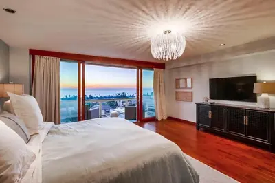 a bedroom with a large white bed and a large window at Seaside in Cardiff-by-the-Sea