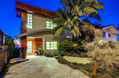 a house with a palm tree in front of it at Seaside in Cardiff-by-the-Sea