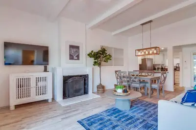 a living room with a table and a fireplace at Jetty View 1 in San Diego