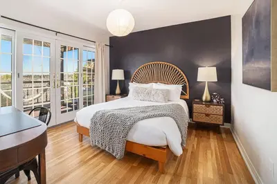 a bedroom with a bed and a desk and windows at Boutique Charm 3BR w/ Huge Deck in Bonita
