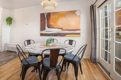 a dining room with a table and chairs and a painting at Boutique Charm 3BR w/ Huge Deck in Bonita