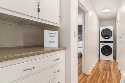 a kitchen with white cabinets and a washer and dryer at Boutique Charm 3BR w/ Huge Deck in Bonita