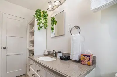 a bathroom with a sink and a mirror at Boutique Charm 3BR w/ Huge Deck in Bonita