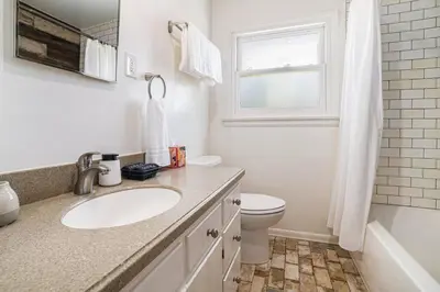 a bathroom with a sink and a toilet and a window at Boutique Charm 3BR w/ Huge Deck in Bonita