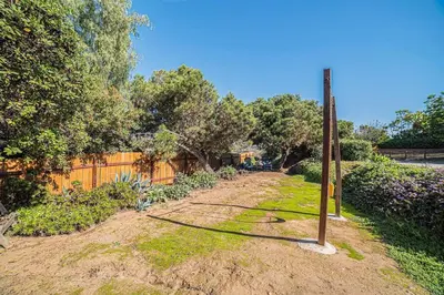a garden with a fence and a wooden pole at One bedroom retreat full kitchen/laundry 1GB Wi-Fi in Bonita