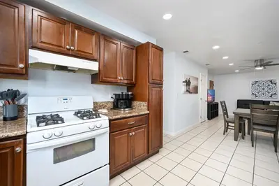 a kitchen with wooden cabinets and a white stove at 4 bedroom home with Patio 10 seconds from the Sand in Newport Beach