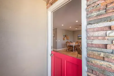 a brick wall with a red door and a dining room at 4 Bedroom Home Steps from the Sand with Balcony & BBQ in Newport Beach