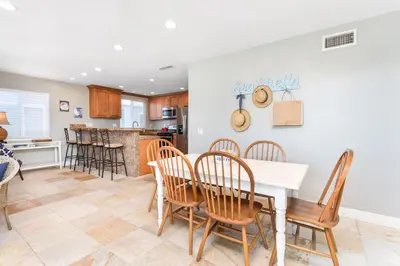 a kitchen and dining room with a table and chairs at 4 Bedroom Home Steps from the Sand with Balcony & BBQ in Newport Beach
