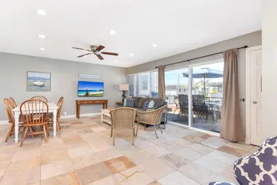 a living room with a table and chairs and a dining room at 4 Bedroom Home Steps from the Sand with Balcony & BBQ in Newport Beach