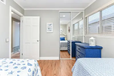 a bedroom with two beds and a mirror at 4 Bedroom Home Steps from the Sand with Balcony & BBQ in Newport Beach