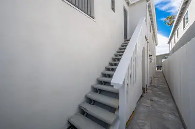 a staircase leading up to a white building at 4 Bedroom Home Steps from the Sand with Balcony & BBQ in Newport Beach
