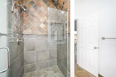 a bathroom with a shower with a glass door at 4 Bedroom Home Steps from the Sand with Balcony & BBQ in Newport Beach