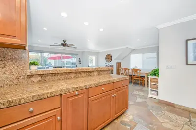 a kitchen with a large counter and a dining room at Giant 7 Bedroom Home with 3 separate Condos in Newport Beach