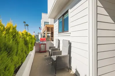 a white building with chairs and a red gas station at BRAND NEW Luxury 1 Bedroom Condo Steps from the Beach in Newport Beach