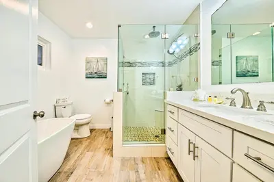 a bathroom with a shower and a toilet and a sink at 6 Bedroom Home with Rooftop Deck Between the Bay & the Beach in Newport Beach