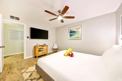 a bedroom with a bed and a flat screen tv at 6 Bedroom Home with Rooftop Deck Between the Bay & the Beach in Newport Beach