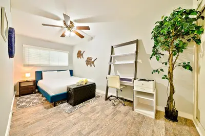 a bedroom with a bed and a desk and a plant at 6 Bedroom Home with Rooftop Deck Between the Bay & the Beach in Newport Beach