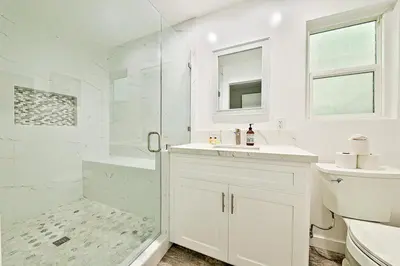 a white bathroom with a sink and a shower at 6 Bedroom Home with Rooftop Deck Between the Bay & the Beach in Newport Beach