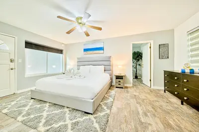 a bedroom with a white bed and a ceiling fan at 6 Bedroom Home with Rooftop Deck Between the Bay & the Beach in Newport Beach