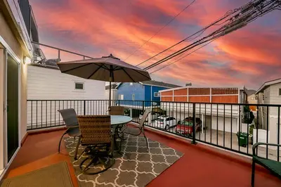 a patio with a table and an umbrella on a balcony at 2 Story Home with Rooftop Deck next to the Bay & Beach in Newport Beach