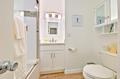 a white bathroom with a toilet and a sink at 2 Story Home with Rooftop Deck next to the Bay & Beach in Newport Beach