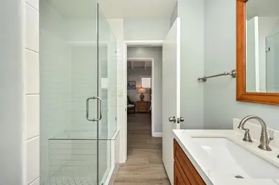 a bathroom with a sink and a glass shower at Oceanfront Home with UNOBSTRUCTED VIEW in Newport Beach