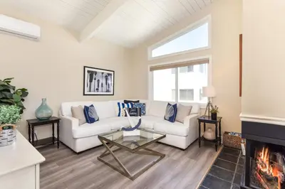 a living room with a white couch and a fireplace at 2 Bedroom in BACK of our BEACHFRONT Home in Newport Beach