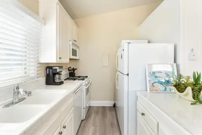 a kitchen with white appliances and a white refrigerator at 2 Bedroom in BACK of our BEACHFRONT Home in Newport Beach