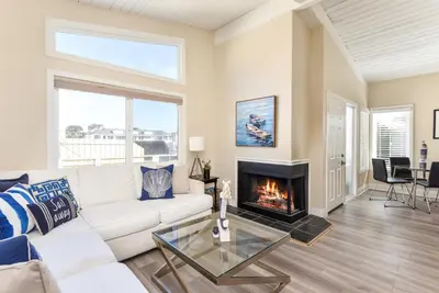 a living room with a white couch and a fireplace at 2 Bedroom in BACK of our BEACHFRONT Home in Newport Beach