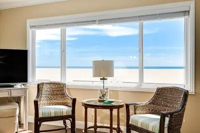 a living room with two chairs and a table and a window at Beachfront Getaway on the Sand in Newport Beach