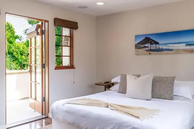 a bedroom with a white bed and a window at Mediterranean Beauty with Rooftop Deck and Views in San Diego