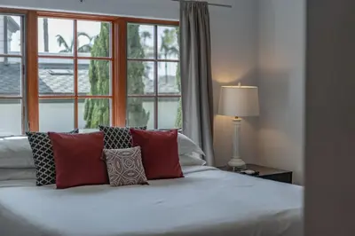 a bedroom with a bed with red pillows and a window at Mediterranean Beauty with Rooftop Deck and Views in San Diego