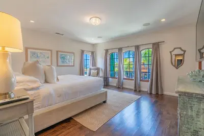 a bedroom with a large white bed and windows at Mediterranean Beauty with Rooftop Deck and Views in San Diego