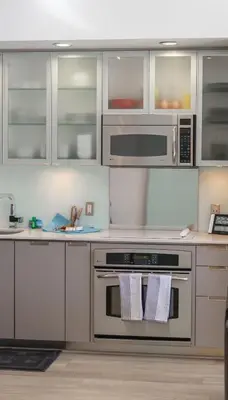a kitchen with stainless steel appliances and white cabinets at Skyline Escape in the Heart of Downtown in San Diego