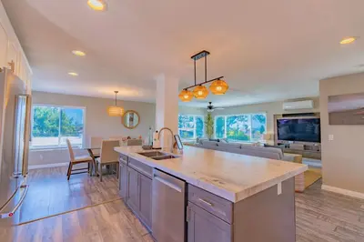 a kitchen and living room with a sink and a table at Surfside Charmer One Block to Beach in San Diego