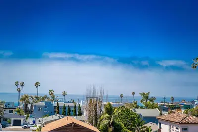 a view of a city with palm trees and the ocean at Surfside Charmer One Block to Beach in San Diego