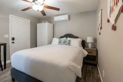 a bedroom with a white bed and a ceiling fan at Surfside Studio Steps to Ocean in San Diego