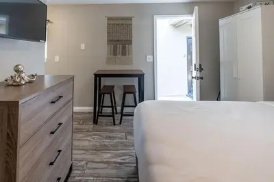 a bedroom with a bed and a table with chairs at Surfside Studio Steps to Ocean in San Diego