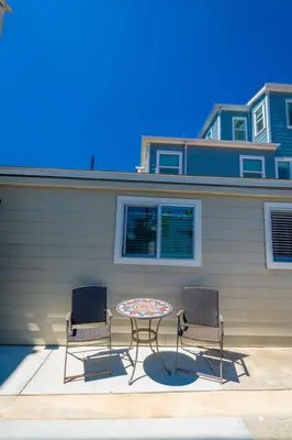 two chairs and a table in front of a house at Surfside Studio Steps to Ocean in San Diego