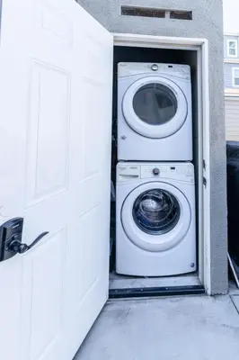a washer and dryer in a garage with a door at Surfside Studio Steps to Ocean in San Diego