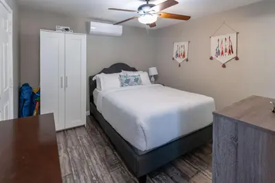 a bedroom with a bed and a ceiling fan at Surfside Studio Steps to Ocean in San Diego