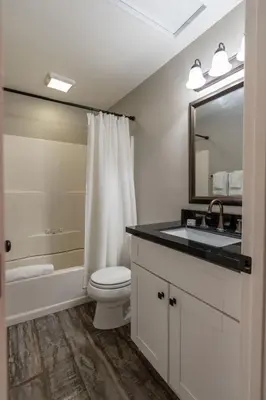 a bathroom with a toilet and a sink and a mirror at Surfside Studio Steps to Ocean in San Diego