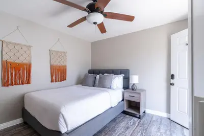 a bedroom with a bed with a ceiling fan at Cozy Beachside Studio in San Diego