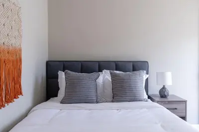 a bedroom with a bed with a black headboard at Cozy Beachside Studio in San Diego