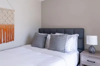 a bedroom with a bed with white sheets and pillows at Cozy Beachside Studio in San Diego