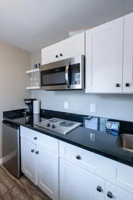 a kitchen with white cabinets and a microwave at Cozy Beachside Studio in San Diego