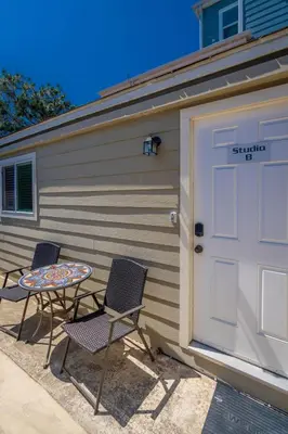 two chairs and a table in front of a garage at Cozy Beachside Studio in San Diego