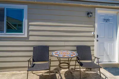 two chairs and a table in front of a house at Cozy Beachside Studio in San Diego