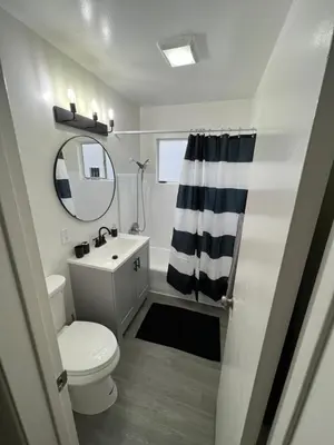 a bathroom with a toilet and a sink and a mirror at The Dugout in San Diego