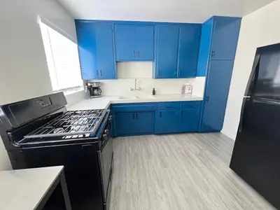 a kitchen with blue cabinets and a black stove at The Dugout in San Diego